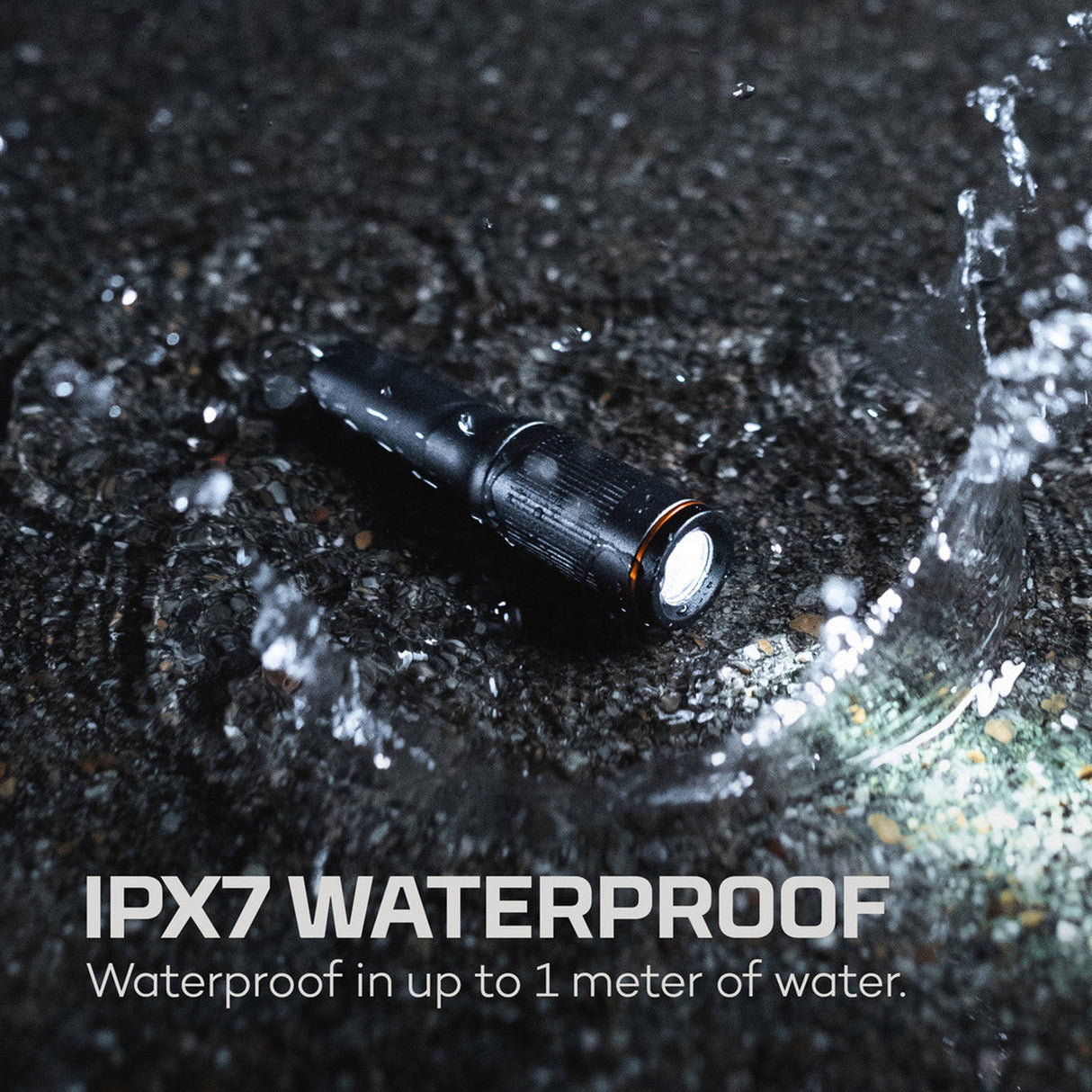 Black waterproof flashlight with water splashing around it.