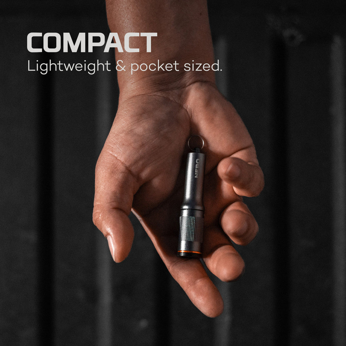 Compact metal flashlight held in an open palm.