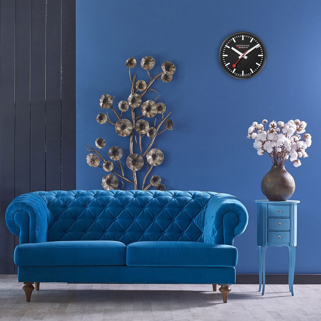 Blue velvet Chesterfield sofa with tufted upholstery and rolled arms.