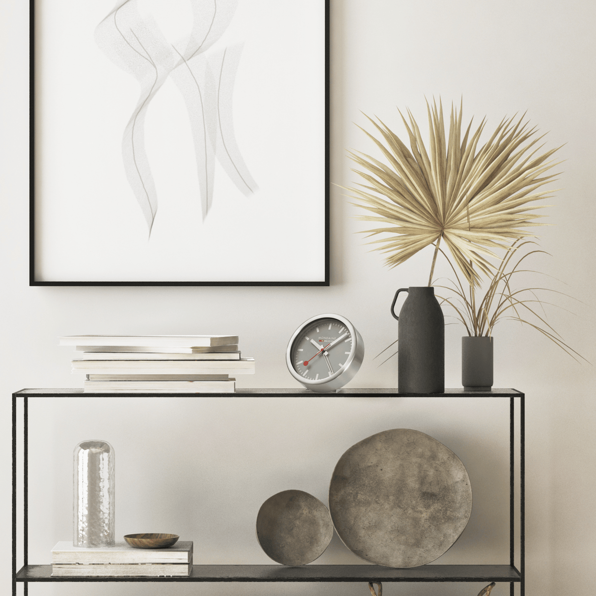 Minimalist console table with metal frame and glass shelves displaying various decorative objects.