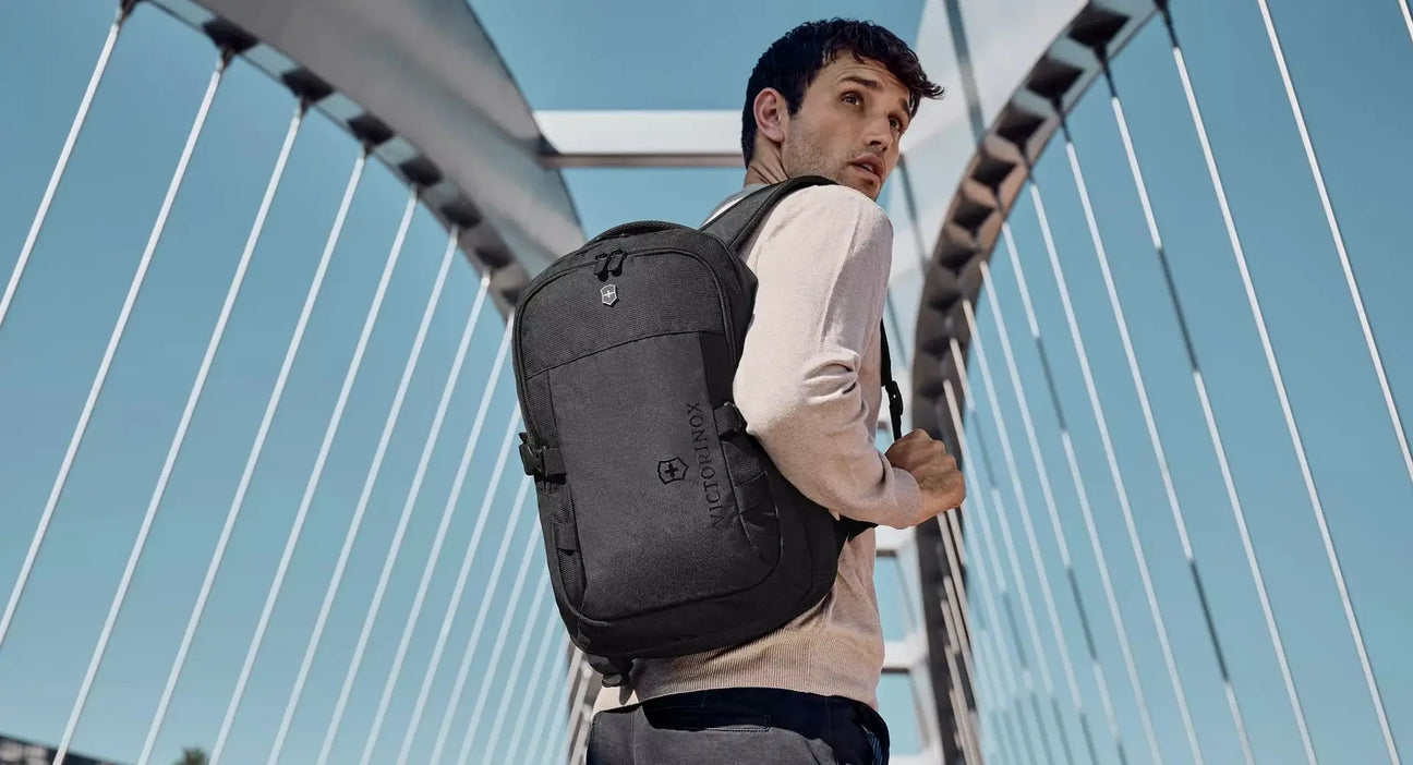 Sleek gray backpack worn by a person on a bridge.