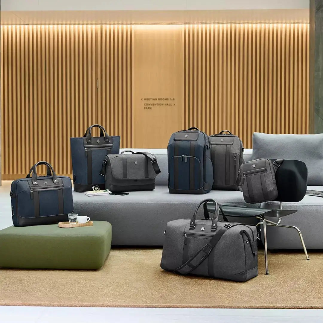 Collection of stylish luggage and travel bags in various sizes and designs, predominantly in shades of blue and gray.