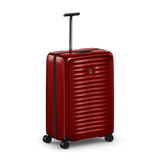 Red hardshell rolling suitcase with horizontal ridges and a retractable handle.