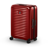 Red hardshell rolling suitcase with horizontal ridges and wheels.