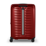 Red hardshell rolling suitcase with horizontal ridges and a telescoping handle.