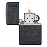 Zippo lighter with intricate engraved patterns on a black matte finish, shown open with a flame.