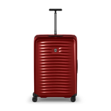 Red hardshell rolling suitcase with horizontal ridges and a retractable handle.