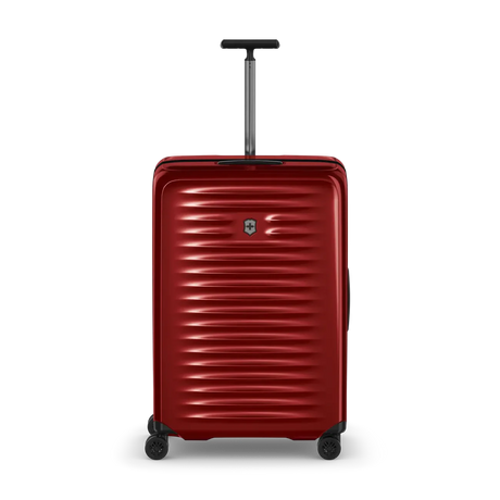 Red hardshell rolling suitcase with horizontal ridges and a retractable handle.