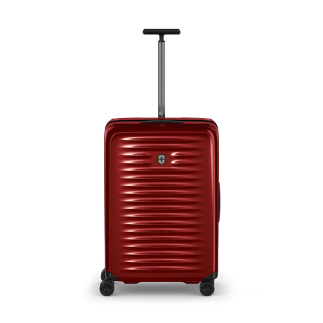 Red hardshell rolling suitcase with horizontal ridges and an extendable handle.