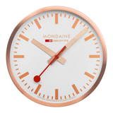 Circular wall clock with a rose gold frame and white face displaying the Mondaine brand.