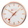 Circular wall clock with a rose gold frame and white face displaying the Mondaine brand.