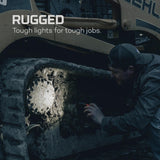 Bright spotlight illuminating a dark, rough surface while a person examines it closely.