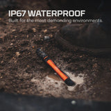 Orange and black waterproof flashlight or torch lying in muddy water.