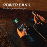 Power bank charging a smartphone, with hands holding both devices.