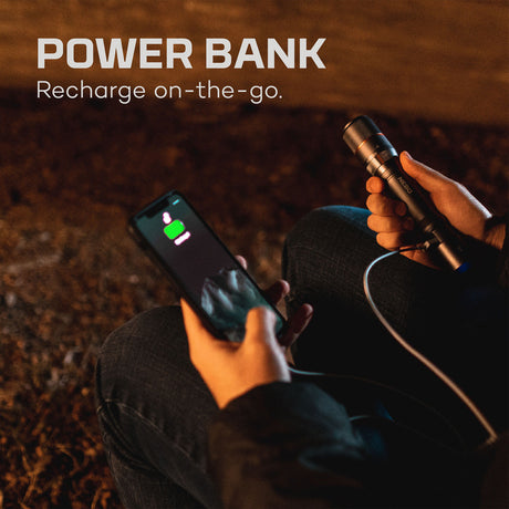 Power bank charging a smartphone, with hands holding both devices.