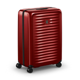 Red hardshell rolling suitcase with horizontal ridges and wheels.