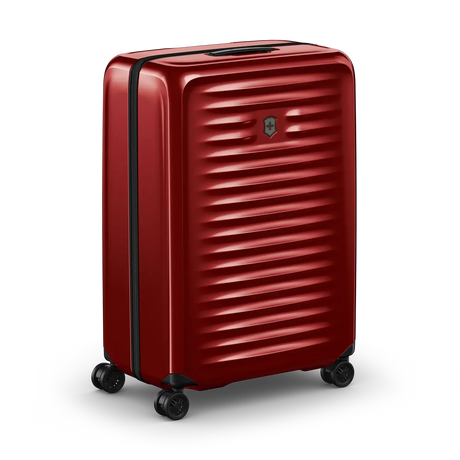 Red hardshell rolling suitcase with horizontal ridges and wheels.
