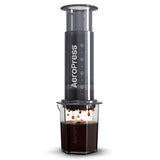AeroPress coffee maker with a clear chamber containing brewed coffee.