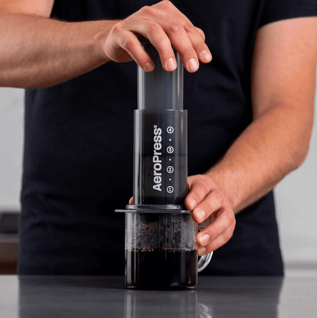 AeroPress coffee maker being used to brew coffee.