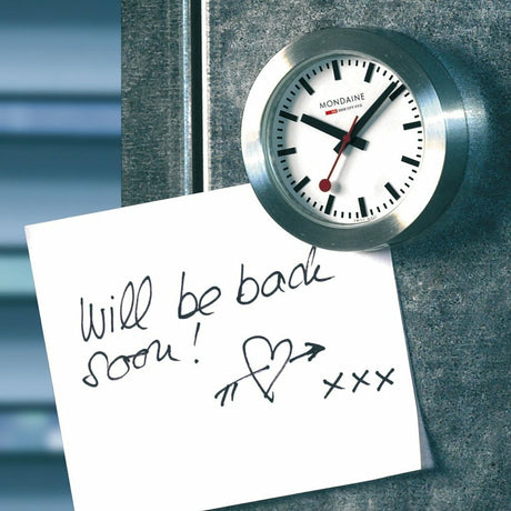 Wall-mounted analog clock with a white face and black hands.